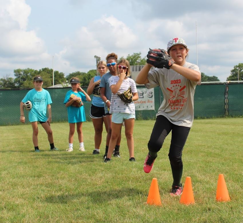 A youth sports team practices softball drills